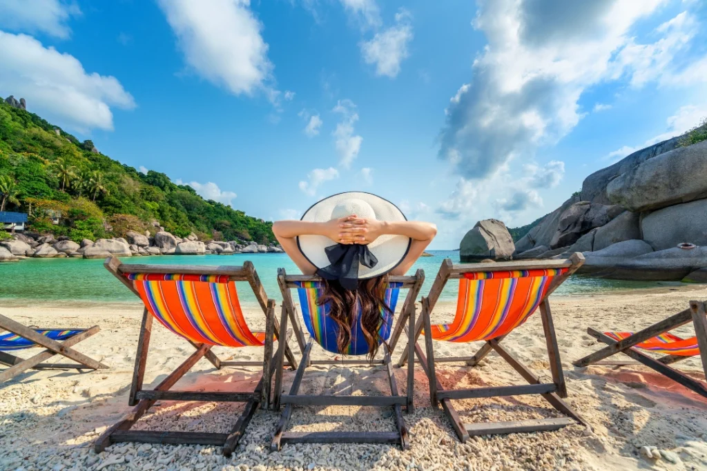 woman with hat sitting chairs beach beautiful tropical beach-woman-relaxing-tropical